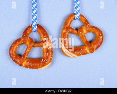 Due pretzel nella forma di cuore su sfondo blu, vista dall'alto Foto Stock