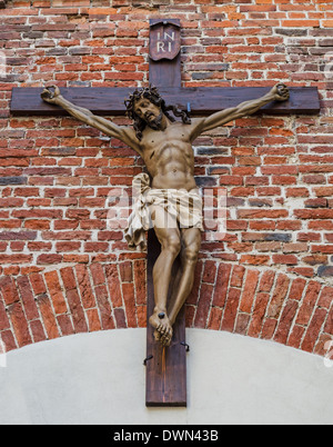 La crocifissione di Gesù Cristo su rosso e parete di mattoni Foto Stock