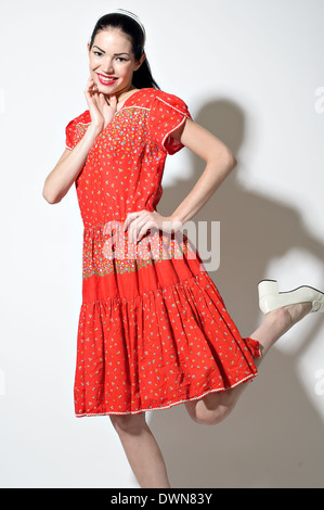 Un retro donna bella donna in posa di un rosso 50s Vintage dress ponendo guardando fiduciosi. Un vintage fashion concept Foto stock Alamy