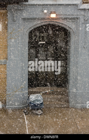 A New York City Mailman del carrello a ruote sul marciapiede durante una tempesta di neve Foto Stock