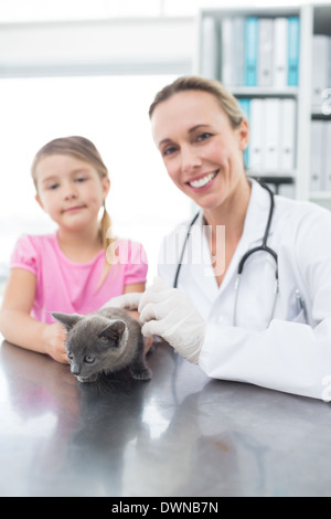 Veterinario e la ragazza con un gattino in clinica Foto Stock