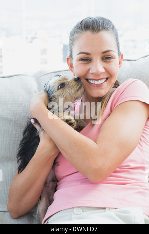 Pretty Woman cuddling suo Yorkshire terrier sul lettino Foto Stock