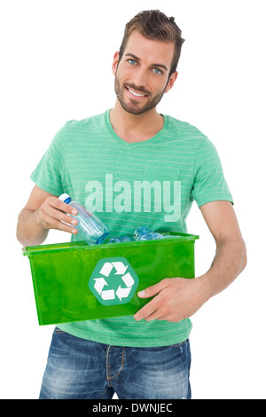 Ritratto di un sorridente giovane uomo che trasportano container di riciclo Foto Stock