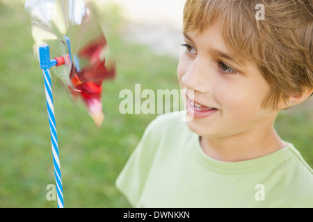 Ragazzo che guarda a girandola in posizione di parcheggio Foto Stock