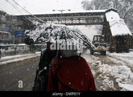 Srinagar Kashmir. Xii Mar, 2014. Un popolo del Kashmir a piedi durante una neve fresca caduta in Srinagar, capitale estiva di indiani controllata kashmir il 11 marzo 2014, il Kashmir ha vitnased hanno la caduta di neve da ultimo due giorni, autorità chiuso tutte le primarie e le scuole medie della regione stradale, il traffico aereo interrotto met office previsioni più neve, hilstorm, Rovesci temporaleschi. © Shafat Sidiq/NurPhoto/ZUMAPRESS.com/Alamy Live News Foto Stock