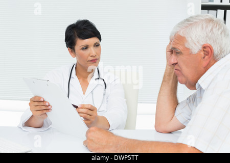 Medico donna che mostra relazioni al paziente senior Foto Stock