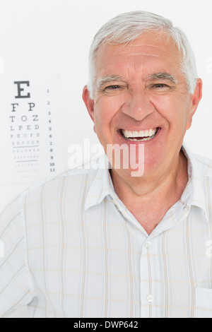 Ritratto di sorridente uomo senior con grafico oculare in background Foto Stock