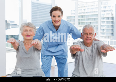 Terapista del sesso femminile aiutando coppia senior con esercizi Foto Stock