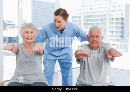 Terapista del sesso femminile aiutando coppia senior con esercizi Foto Stock