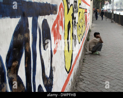 Strade di Calcutta, uomo accucciata sulla strada 30 gennaio 2009 in Kolkata, West Bengal, India Foto Stock