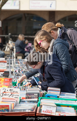 Ragazze rovistando tra l DVD sul mercato in stallo. Foto Stock