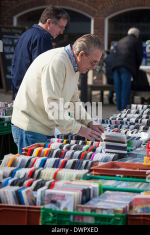 L uomo ricerca attraverso i DVD sul mercato in stallo. Foto Stock