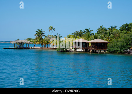 Honduras, dell Honduras Isole della baia, Roatan, Sandy Bay, Anthony's chiave. Resort bungalows lungo la scenic tropical caye Foto Stock