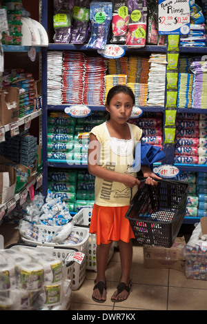 Una giovane ragazza detiene sul carrello in un supermercato nella città di montagna di Juayua sul rutas de la flores in El Salvador Foto Stock