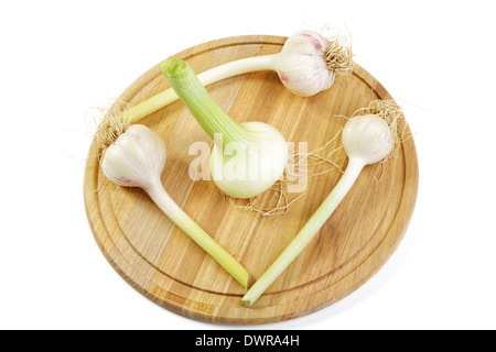Aglio e Cipolle testate su un tagliere.Sfondo bianco Foto Stock