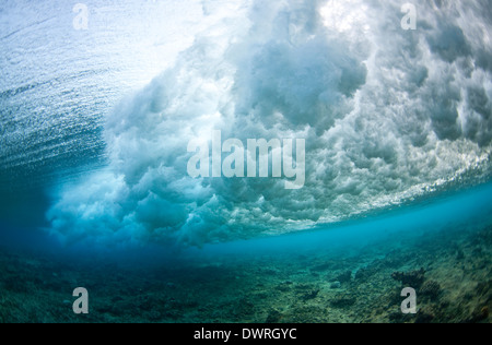 Vista subacquea unica di un'onda che si infrange su una barriera corallina Nelle Maldive Foto Stock