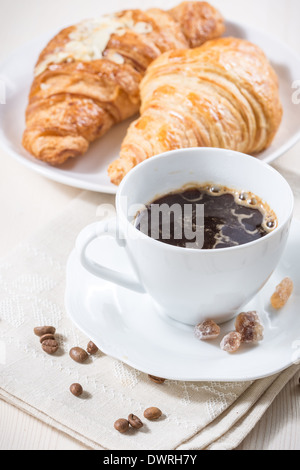 Tazza di caffè nero e cornetti freschi. Foto Stock