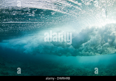 Vista subacquea unica di un'onda che si infrange su una barriera corallina Nelle Maldive Foto Stock