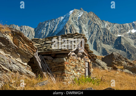 Shephard capanna di pietra nella Val d'Hérens valley, picco Dent de Perroc dietro, Arolla, Vallese, Svizzera Foto Stock