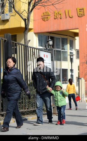 (140313) -- Xi'an, 13 marzo 2014 (Xinhua) -- un genitore e un bambino hanno una passeggiata al di fuori della Fengyun Lanwan Kindergarten, che è stato chiuso per dare ai bambini di farmaci antivirali, a Xi'an, capitale della Cina nord-occidentale della provincia di Shaanxi, 13 marzo 2014. Il Fengyun Lanwan Kindergarten e Hongji Xincheng Kindergarten qui sono state chiuse il 11 marzo dopo i genitori divulgato la scuola è stata per lungo tempo la somministrazione di farmaci antivirali per bambini. La polizia ha messo il asili privati' rappresentante legale, principale e kindergarten medico nella custodia. Alcuni genitori dice Xinhua i loro bambini sono state vivendo il disco Foto Stock