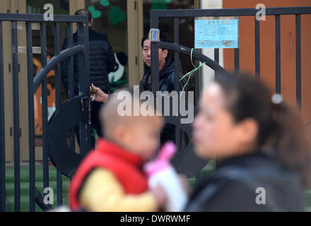 (140313) -- Xi'an, 13 marzo 2014 (Xinhua) -- un genitore e bambino sono visti al di fuori del Hongji Xincheng Kindergarten, che è stato chiuso per dare ai bambini di farmaci antivirali, a Xi'an, capitale della Cina nord-occidentale della provincia di Shaanxi, 13 marzo 2014. Il Fengyun Lanwan Kindergarten e Hongji Xincheng Kindergarten qui sono state chiuse il 11 marzo dopo i genitori divulgato la scuola è stata per lungo tempo la somministrazione di farmaci antivirali per bambini. La polizia ha messo il asili privati' rappresentante legale, principale e kindergarten medico nella custodia. Alcuni genitori dice Xinhua i loro bambini sono state vivendo discom Foto Stock