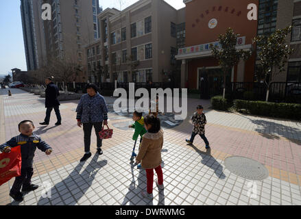 (140313) -- Xi'an, 13 marzo 2014 (Xinhua) -- i genitori e i bambini sono visti al di fuori del Hongji Xincheng Kindergarten, che è stato chiuso per dare ai bambini di farmaci antivirali, a Xi'an, capitale della Cina nord-occidentale della provincia di Shaanxi, 13 marzo 2014. Il Fengyun Lanwan Kindergarten e Hongji Xincheng Kindergarten qui sono state chiuse il 11 marzo dopo i genitori divulgato la scuola è stata per lungo tempo la somministrazione di farmaci antivirali per bambini. La polizia ha messo il asili privati' rappresentante legale, principale e kindergarten medico nella custodia. Alcuni genitori dice Xinhua i loro bambini sono state vivendo discom Foto Stock