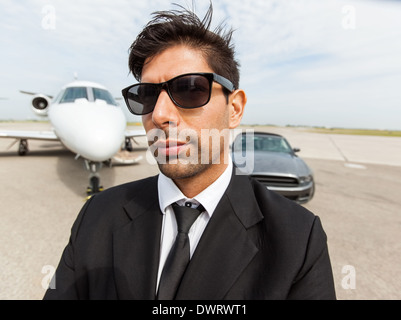 Imprenditore fiducioso nella parte anteriore della vettura e jet privato Foto Stock