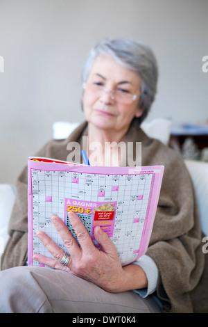 Persona anziana facendo cr-parola puzzle Foto Stock