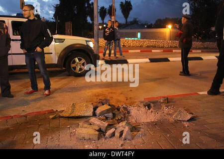 Gerusalemme, Israele. Xii Mar, 2014. Le persone si radunano intorno a un foro provocato da un razzo lanciato dalla striscia di Gaza a sderot, Israele sud, il 12 marzo 2014. Militanti hanno sparato più di trenta razzi dalla striscia di Gaza In Israele il mercoledì sera, secondo l'esercito israeliano. Non si hanno notizie di lesioni finora. Il la Jihad islamica palestinese, una delle diverse fazioni militante operanti nell'enclave palestinese, rivendicato la responsabilità per il lancio di missili, secondo palestinese relazioni media. Credito: JINI/Xinhua/Alamy Live News Foto Stock