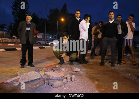 Gerusalemme, Israele. Xii Mar, 2014. Le persone si radunano intorno a un foro provocato da un razzo lanciato dalla striscia di Gaza a sderot, Israele sud, il 12 marzo 2014. Militanti hanno sparato più di trenta razzi dalla striscia di Gaza In Israele il mercoledì sera, secondo l'esercito israeliano. Non si hanno notizie di lesioni finora. Il la Jihad islamica palestinese, una delle diverse fazioni militante operanti nell'enclave palestinese, rivendicato la responsabilità per il lancio di missili, secondo palestinese relazioni media. Credito: JINI/Xinhua/Alamy Live News Foto Stock