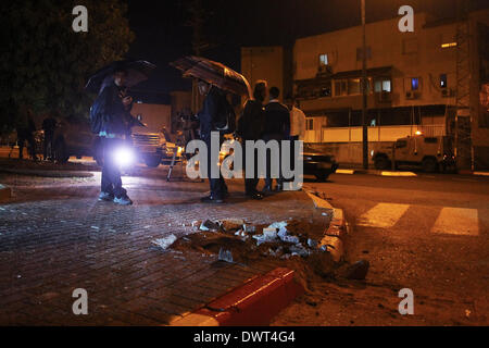 Gerusalemme, Israele. Xii Mar, 2014. Le persone si radunano intorno a un foro provocato da un razzo lanciato dalla striscia di Gaza a sderot, Israele sud, il 12 marzo 2014. Militanti hanno sparato più di trenta razzi dalla striscia di Gaza In Israele il mercoledì sera, secondo l'esercito israeliano. Non si hanno notizie di lesioni finora. Il la Jihad islamica palestinese, una delle diverse fazioni militante operanti nell'enclave palestinese, rivendicato la responsabilità per il lancio di missili, secondo palestinese relazioni media. Credito: JINI/Xinhua/Alamy Live News Foto Stock