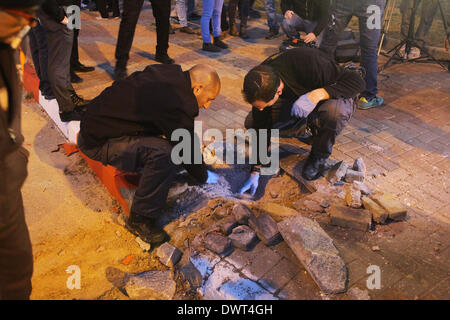 Gerusalemme, Israele. Xii Mar, 2014. La sicurezza di Israele membri controlla un foro provocato da un razzo lanciato dalla striscia di Gaza a sderot, Israele sud, il 12 marzo 2014. Militanti hanno sparato più di trenta razzi dalla striscia di Gaza In Israele il mercoledì sera, secondo l'esercito israeliano. Non si hanno notizie di lesioni finora. Il la Jihad islamica palestinese, una delle diverse fazioni militante operanti nell'enclave palestinese, rivendicato la responsabilità per il lancio di missili, secondo palestinese relazioni media. Credito: JINI/Xinhua/Alamy Live News Foto Stock