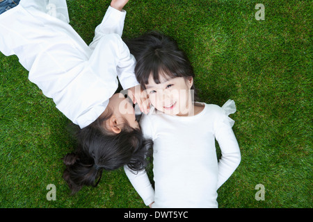 Due ragazze sdraiati sull'erba Foto Stock