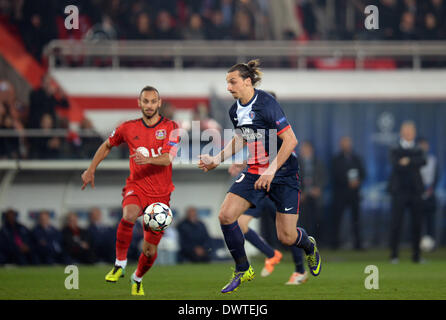 Leverkusen's Omer Toprak (L) il sistema VIES per la palla con il PSG Zlatan Ibrahimovic durante la UEFA Champions League round di 16 seconda gamba partita di calcio tra Paris Saint Germain e Bayer 04 Leverkusen presso il Parc de Princes, Parigi, Francia, 12 marzo 2014. Foto: Federico Gambarini/dpa Foto Stock