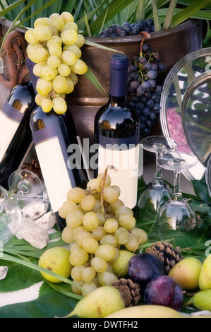 Le bottiglie di vino e uva durante un giorno di nozze Foto Stock