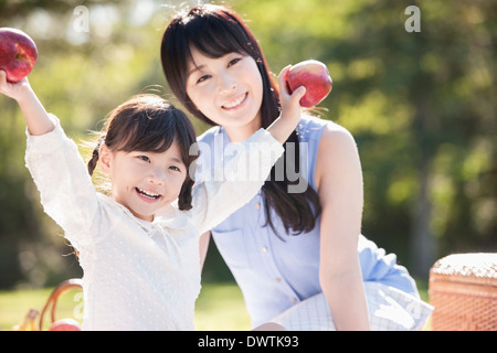 Una madre e una figlia mangiare frutta nella natura Foto Stock