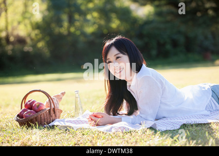 Una donna sdraiata sull'erba Foto Stock