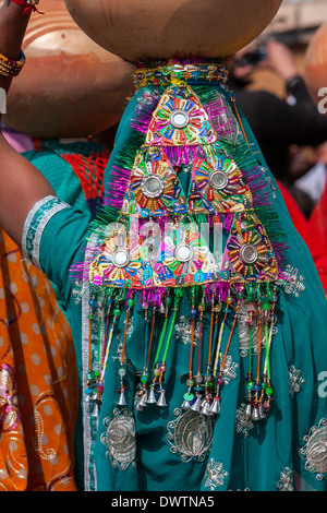 Abhaneri, Rajasthan, India. Sequined multicolore Copricapo di una donna che cammina per una sposa in casa di un pre-la celebrazione dei matrimoni. Foto Stock