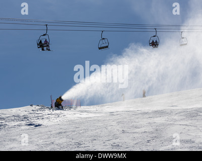 Irrorazione di innevamento artificiale neve sulle piste per sciatori in montagna Foto Stock