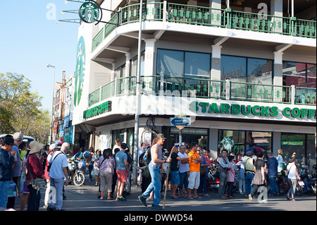 La folla lungo le strade al di fuori di Starbucks Coffee shop in Chiang Mai in attesa per l'annuale Festival dei fiori sfilano per iniziare. Foto Stock