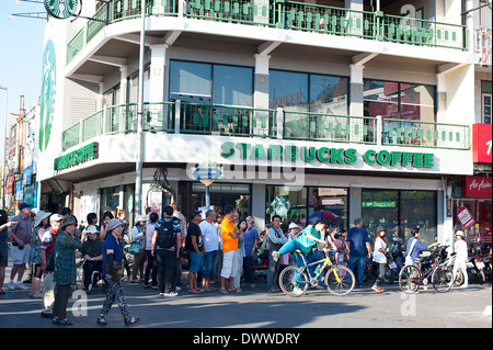 La folla lungo le strade al di fuori di Starbucks Coffee shop in Chiang Mai in attesa per l'annuale Festival dei fiori sfilano per iniziare. Foto Stock