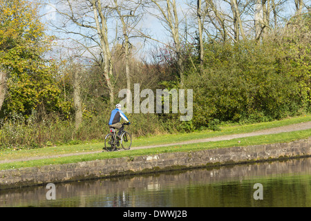 Ciclista sulla strada alzaia del canale Leeds-Liverpool a Aspull, Lancashire. L'alzaia è parte dell'Whelley linea Loop cycleway Foto Stock