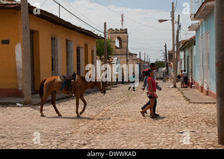 Coppia di cuba con l uomo che conduce un cavallo a piedi in strada di ciottoli in Trinidad, Cuba Foto Stock