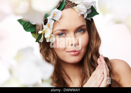 Isolate il ritratto di una giovane alla perfezione con i capelli decorato con fiori Foto Stock