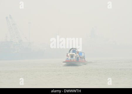 Selangor, Malaysia. Il 14 marzo 2014. Una barca è visto che viaggiano nella foschia in Port Klang, Malaysia, Marzo 14, 2014. Le scuole sono chiuse il venerdì a causa dell'aria malsana. L'aria inquinante index (API) di Port Klang, situata ad ovest della capitale Kuala Lumpur, hit livello malsano venerdì, secondo il sito del Dipartimento di Ambiente della Malesia. (Xinhua/Chong Voon Chung) (lmz) Foto Stock