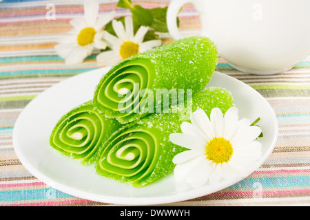 Green Candy Fruit su una piastra con la camomilla Foto Stock