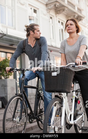 Giovane con le biciclette su strada di città Foto Stock