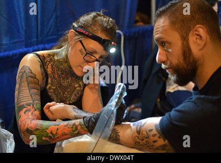 L uomo come ottenere un avambraccio tatuaggio al Tattoo Convention di New York a Manhattan al Roseland Ballroom di New York City Foto Stock