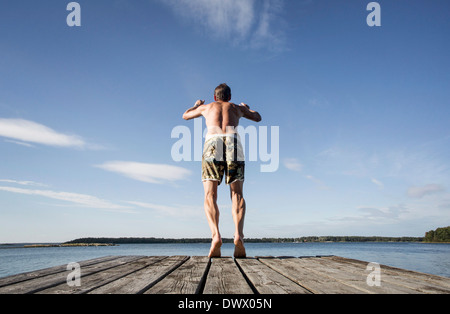 Vista posteriore di uomo maturo le immersioni in mare Foto Stock