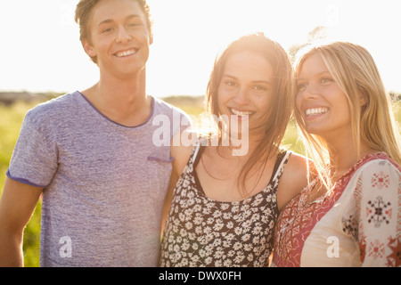 Ritratto di donna felice in piedi con gli amici all'aperto Foto Stock